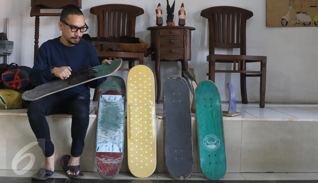 Pemilik brand kacamata kayu Kabau Bonny Andrew memilih sebuah papan skateboard di studio Namines, Jakarta (18/08). Kacamata kayu Kabau Brand lokal asal Jakarta dirintis tahun 2012 di buat dengan papan bekas skateboard.(Liputan6.com/Herman Zakharia)