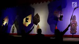 Dalang Ki Anom Dwijo Kangko memainkan pertunjukan wayang kulit lakon "Bima Jumeneng Guru Bangsa" di Tugu Proklamasi, Jakarta, Sabtu (27/1). Pertunjukan wayang kulit ini dibuka Ketua Umum PDIP Megawati Soekarnoputri. (Liputan6.com/Johan Tallo)