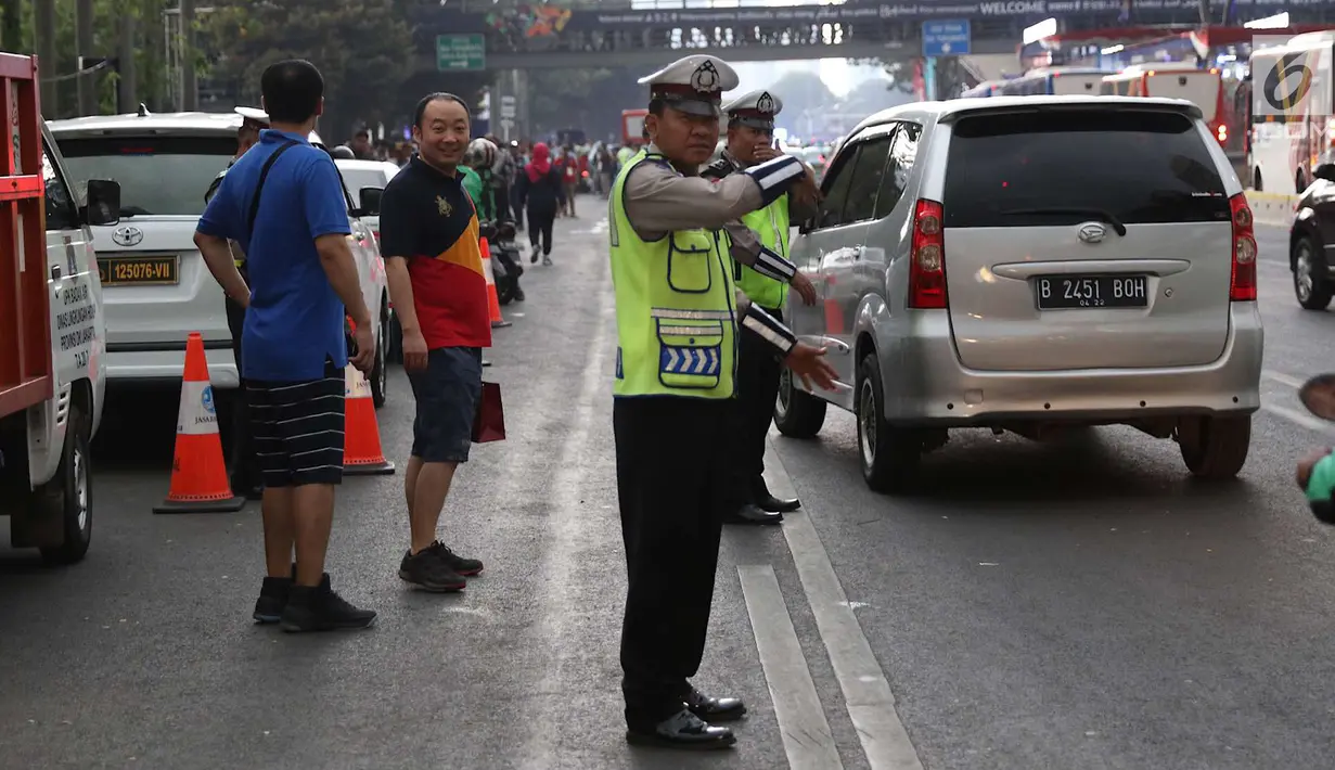 Polisi mengatur lalu lintas di kawasan Senayan, Jakarta, Minggu (2/9). Untuk meminimalisasi kemacetan jelang penutupan Asian Games 2018, rekayasa lalu lintas dilakukan di sejumlah ruas jalan dari dan menuji Senayan. (Liputan6.com/Immanuel Antonius)