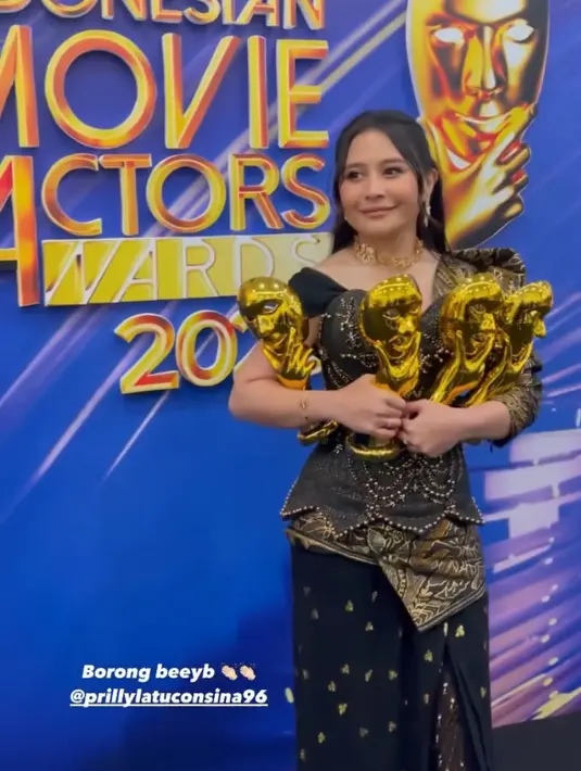 Membawa pulang empat piala, Prilly Latuconsina mengenakan gaun didominasi warna hitam dengan aksen batik di beberapa bagian. Dipadukan aksesori kalung dan anting-anting keemasan .[@andreapanaga]