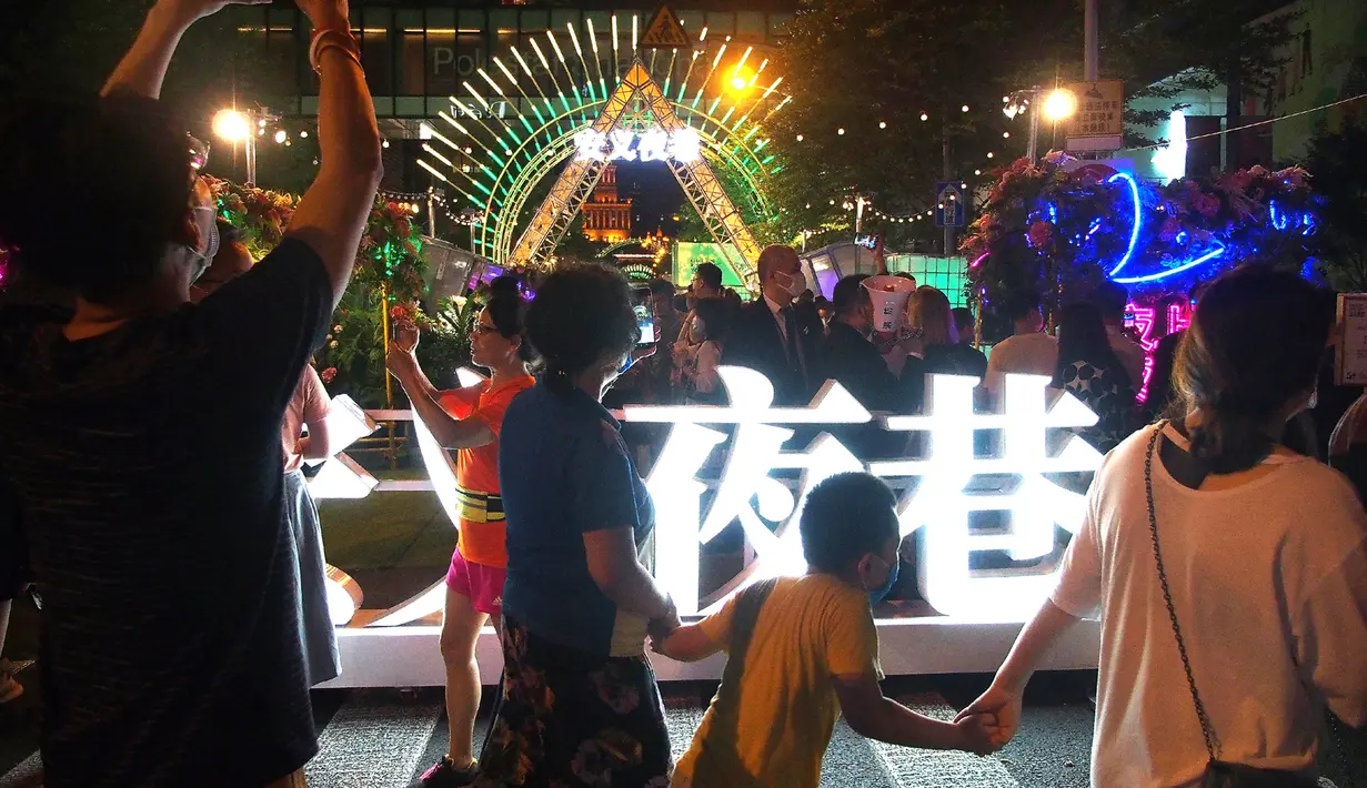 Orang-orang menikmati waktu luang mereka di sebuah jalan di Shanghai, pada 7 Juni 2020. Berbagai bar, museum, toko buku, pusat perbelanjaan, serta kompleks komersial penting bergabung ke dalam festival yang digelar untuk mendorong aktivitas perekonomian malam hari di kota tersebut. (Xinhua/Chen Fei)