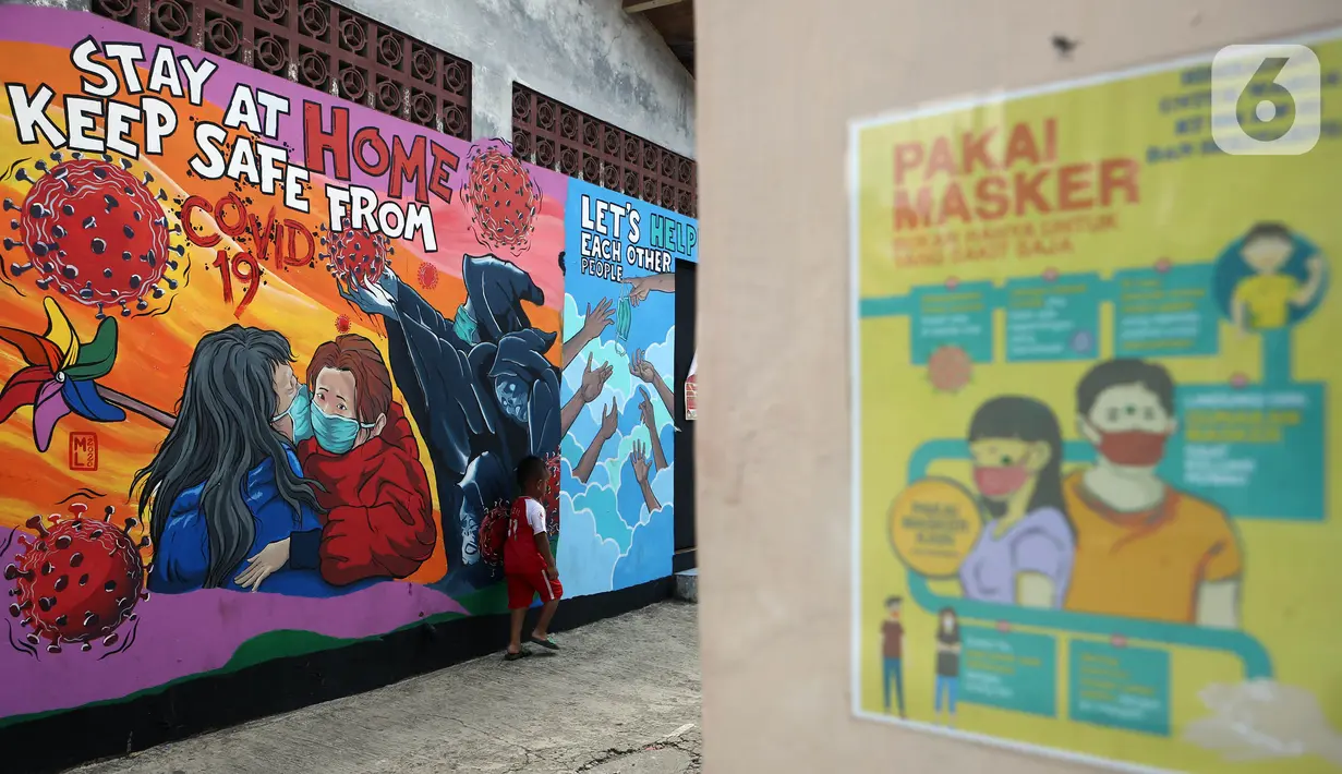 Seorang anak berdiri depan mural bertema virus corona COVID-19 yang menghiasi dinding rumah di kawasan Pangkalan Jati Baru, Depok, Jawa Barat, Selasa (2/6/2020). Mural bertulis ‘Stay At Home, Keep Safe From COVID-19’ itu untuk mengingatkan warga akan bahaya COVID-19. (Liputan6.com/Johan Tallo)