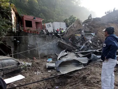 Warga melihat rumah rusak akibat tanah longsor di Santa Catarina Pinula, Guatemala (2/10/2015). Menurut media lokal, enam mayat ditemukan dari lumpur, dan sekitar 40 rumah hancur, setelah tanah longsor yang disebabkan hujan lebat. (REUTERS/Josue Decavele)