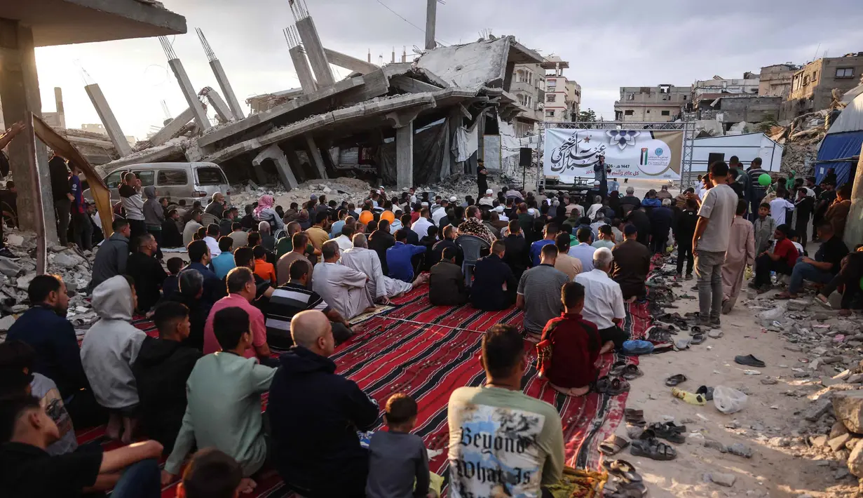 Warga Palestina berkumpul di jalan yang rusak parah untuk melaksanakan salat menandai dimulainya Idul Adha, Hari Raya Kurban, di Khan Yunis, Jalur Gaza Selatan, pada Rabu 27 Mei 2026. (BASHAR TALEB/AFP)