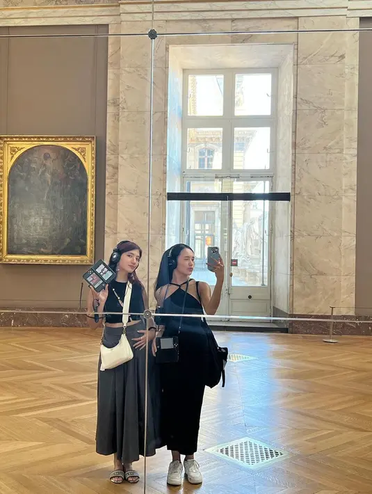 Gaya museum date with bestie ala Beby Tsabina dan Cassandra Lee. Beby tampil menawan mengenakan dress hitam dengan detail cross neck, sedangkan Cassandra tampil memakai tank top hitam dan rok abu-abu yang panjang. [Foto: Instagram/bebytsabina]