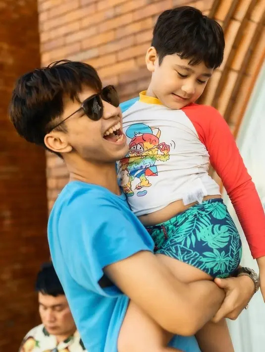 Rafathar tak sungkan minta gendong ke Dimas Ahmad. Dimas pun dengan sumringahnya gendong Rafathar. Momen Rafathar digendong Dimas pun memperlihatkan bahwa keduanya akur dan kompak. (Liputan6.com/IG/@dimas_baam)