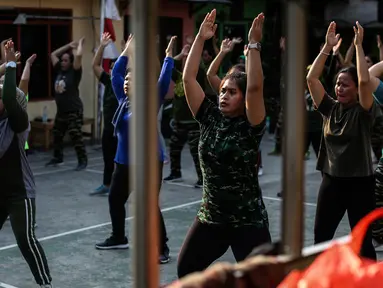 Sejumlah perempuan mengikuti senam bersama di sebuah lapangan kawasan Jakarta, Rabu (25/8/2021). Untuk menjaga tubuh tetap sehat dan imun yang terjaga di kala pandemi, warga melakukan senam rutin yang dipimpin instruktur seminggu sekali. (Liputan6.com/Johan Tallo)