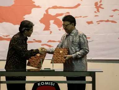 Mendagri, Tjahjo Kumolo (kanan) bersalaman dengan pelaksana tugas Ketua KPU Hadar Nafis Gumay usai penyerahan DP4 & DAK2 Pilkada Serentak 2017 di Kantor Komisi Pemilihan Umum (KPU), Jakarta, Kamis (14/7). (Liputan6.com/Faizal Fanani)