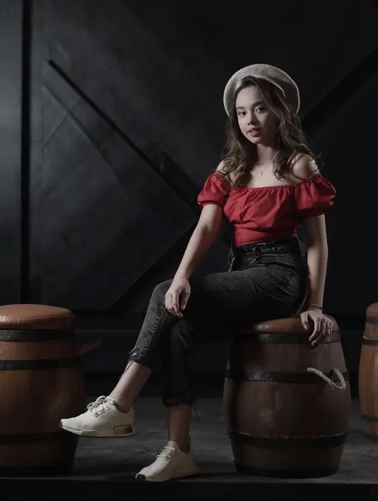 Pakai baret berwarna khaki yang dipadukan dengan atasan off shoulder merah marun, gaya Lyodra berkesan aura feminin. (Liputan6.com/IG/@lyodraofficial)