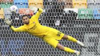 Kiper AC Milan, Gianluigi Donnarumma, berusaha menghalau bola saat melawan Udinese pada laga Liga Italia di Stadion Friuli, Minggu (1/11/2020). AC Milan menang dengan skor 2-1. (Andrea Bressanutti/LaPresse via AP)