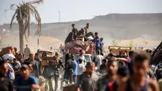 Orang-orang berjalan membawa paket bantuan kemanusiaan yang mereka terima dari pusat distribusi yang dikelola oleh Yayasan Kemanusiaan Gaza (GHF) yang didukung Amerika Serikat (AS) dan Israel, di koridor Netzarim, Nuseirat, Jalur Gaza tengah, pada 30 September 2025. (Eyad BABA/AFP)