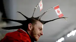 Seorang pria menata rambutnya dengan unik saat menyaksikan cabang curling antara Rusia dan Swiss pada Olimpiade Musim Dingin 2018 di Gangneung, Korea Selatan, Senin (12/2). Ada 92 negara peserta yang mengikuti ajang tersebut. (AP/Natacha Pisarenko)