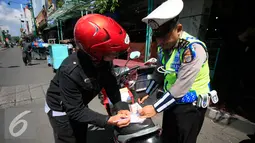 Polisi saat menilang pengendara motor pada Operasi Progo Patuh di Jl Malioboro, Yogyakarta, Rabu (18/5). Operasi Patuh di gelar secara serempak di seluruh Indonesia hingga 29 Mei 2016. (Liputan6.com/Boy Harjanto)