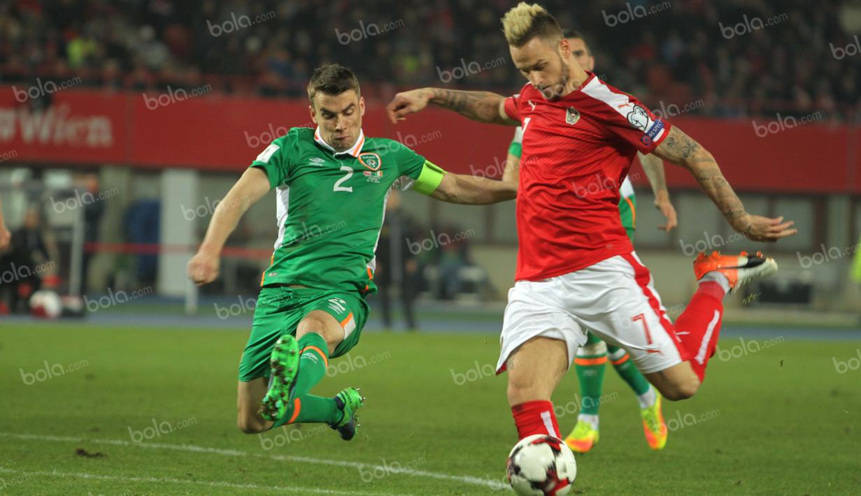 Kapten Irlandia, Seamus Coleman (kiri), mencoba menghadang tendangan keras winger Austria, Marko Arnautovic. (Bola.com/Reza Khomaini)