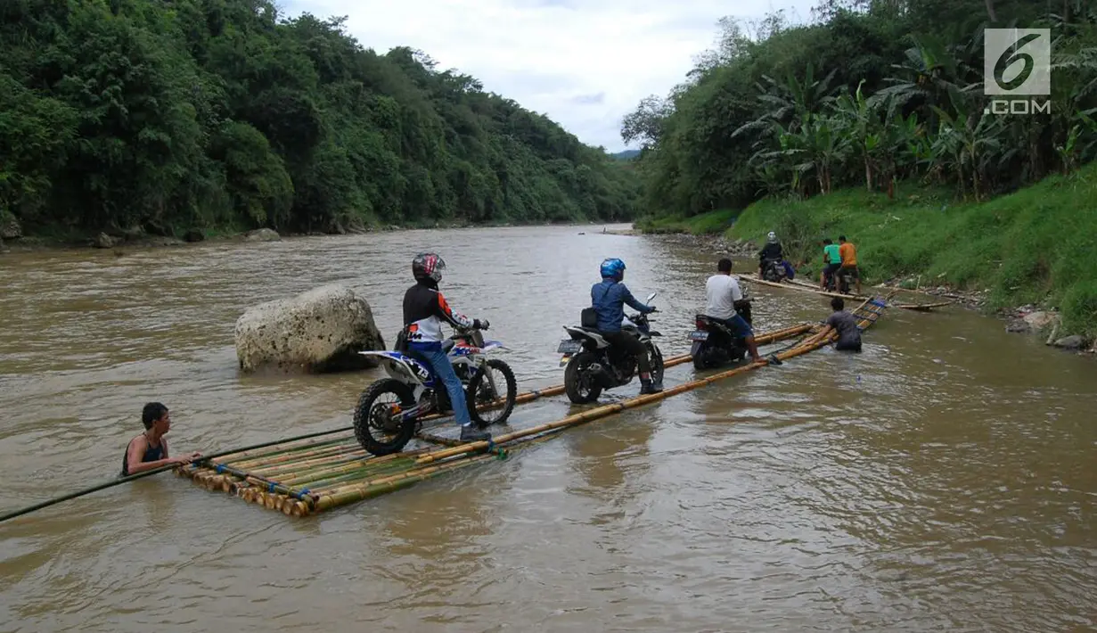 Sebuah rakit mengangkut motor dan warga menyeberangi Sungai Cisadane di Rumpin, Bogor, Selasa (13/3). Mereka terpaksa menaiki rakit akibat jembatan yang merupakan akses jalan utama Ciseeng -Rumpin masih dalam perbaikan. (Liputan6.com/Achmad Sudarno)