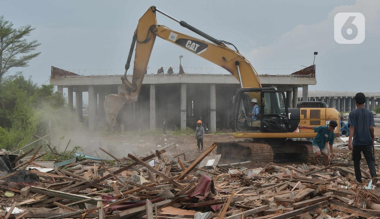 Petugas menggunakan alat berat saat pembebasan lahan proyek Jalan Tol CIbitung-CIlincing seksi 4 di kawasan Semper Timur, Cilincing, Jakarta Utara, Selasa (8/11/2022).  PT Cibitung Tanjung Priok Port Tollways (CTP Tollways) sebagai Badan Usaha Jalan Tol (BUJT) mencatat progres pembebasan lahan untuk seksi 4 sepanjang 7,28 km telah mencapai 100% dan ditargetkan pembangunannya selesai pada akhir tahun 2022. (Liputan6.com/Herman Zakharia)