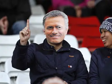  Seorang suporter menggunakan topeng pelatih Chelsea Jose Mourinho pada laga Liga Premier Inggris di Stadion Britania, Minggu (8/11/2015) dini hari WIB. Mourinho dilarang mendampingi timnya oleh Football Association ( FA ). ( Reuters/ Ed Sykes)
