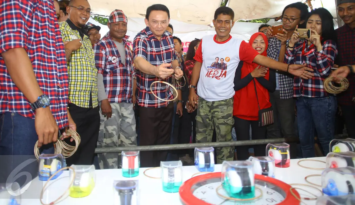 Cagub DKI Jakarta, Basuki T Purnama saat bermain dalam acara "Bersyukur Jakarta", Jumat (20/1). Dalam acara yang berbentuk bakti sosial dan pasar murah tersebut, terdapat hiburan dan permainan anak. (Liputan6.com/Immanuel Antonius)