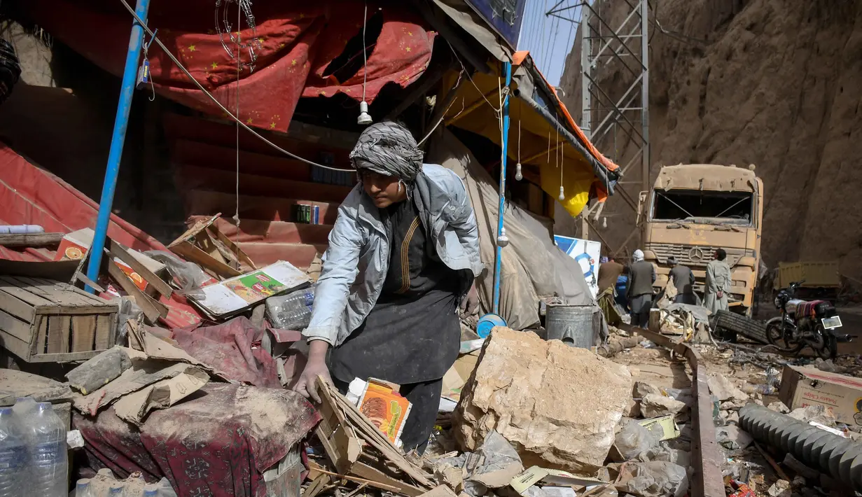 Seorang pemilik toko di Afghanistan mencari sisa-sisa bangunan di depan toko yang rusak di sepanjang jalan raya setelah gempa bumi di Tang-e Tashqurghan, distrik Khulm, provinsi Samangan, pada Senin 3 November 2025. Menurut Survei Geologi Amerika Serikat (USGS), gempa tersebut memiliki berkekuatan magnitudo 6,3 dengan kedalaman 28 km. (Atif Aryan/AFP)