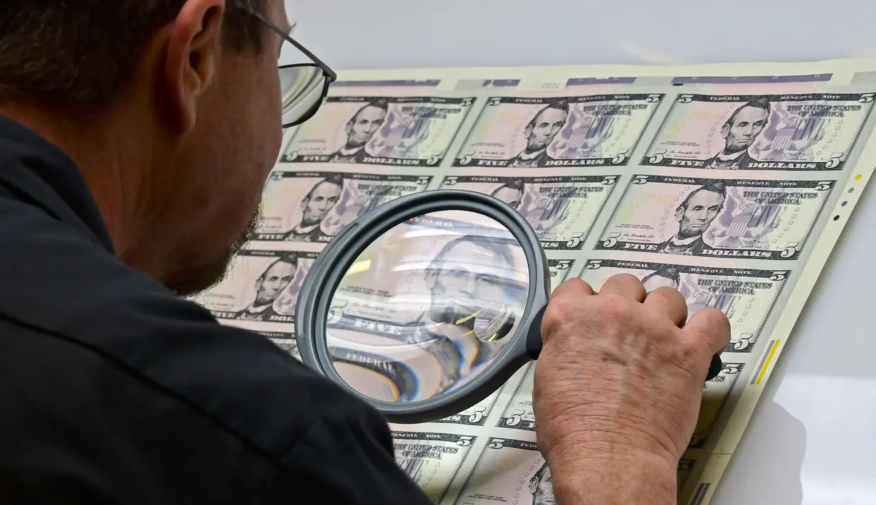 Pekerja menelaah paket lembaran 5 USD setelah keluar dari mesin cetak di Biro Pengukiran dan Percetakan AS, Washington, Amerika Serikat, Jumat (20/7). (Eva HAMBACH/AFP)