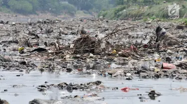 Tumpukkan sampah yang muncul di permukaan Kanal Banjir Barat, Jakarta, Selasa (16/7/2019). Kemarau sejak dua bulan terakhir ini menyebabkan sampah-sampah yang mengendap di dasar sungai muncul ke permukaan sehingga menimbulkan bau tak sedap. (merdeka.com/Iqbal S Nugroho)