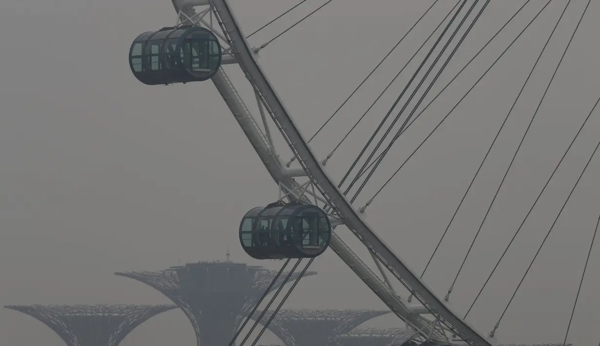 Orang-orang melihat pemandangan dari Singapore Flyer Observation Wheel, Senin (5/10). Indeks Standar Polutan (PSI) kabut asap mencapai angka tertinggi 186 pada jam 4 sore waktu setempat, menurut Badan Lingkungan Nasional. (REUTERS/Edgar Su)