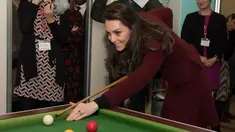 Kate Middleton bersiap memukul bola ketika bermain biliar saat kunjungannya ke MIST, sebuah tempat kesehatan mental bagi anak di Pontypool, Wales, Inggris (22/2). Kate terlihat menikmati permainan biliar tersebut. (AFP Photo / Pool / Paul Edwards)