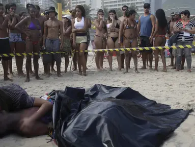 Wanita bernama  Eliane mencium suaminya yang tewas Eduardo Marinho Albuquerque di pantai, Rio de Janeiro , Brasil , 21 April 2016. Menurut kabar pria ini tewas setelah terjatuh dari bangunan yang runtuh akibat diterjang ombak. (REUTERS / Ricardo Moraes) 