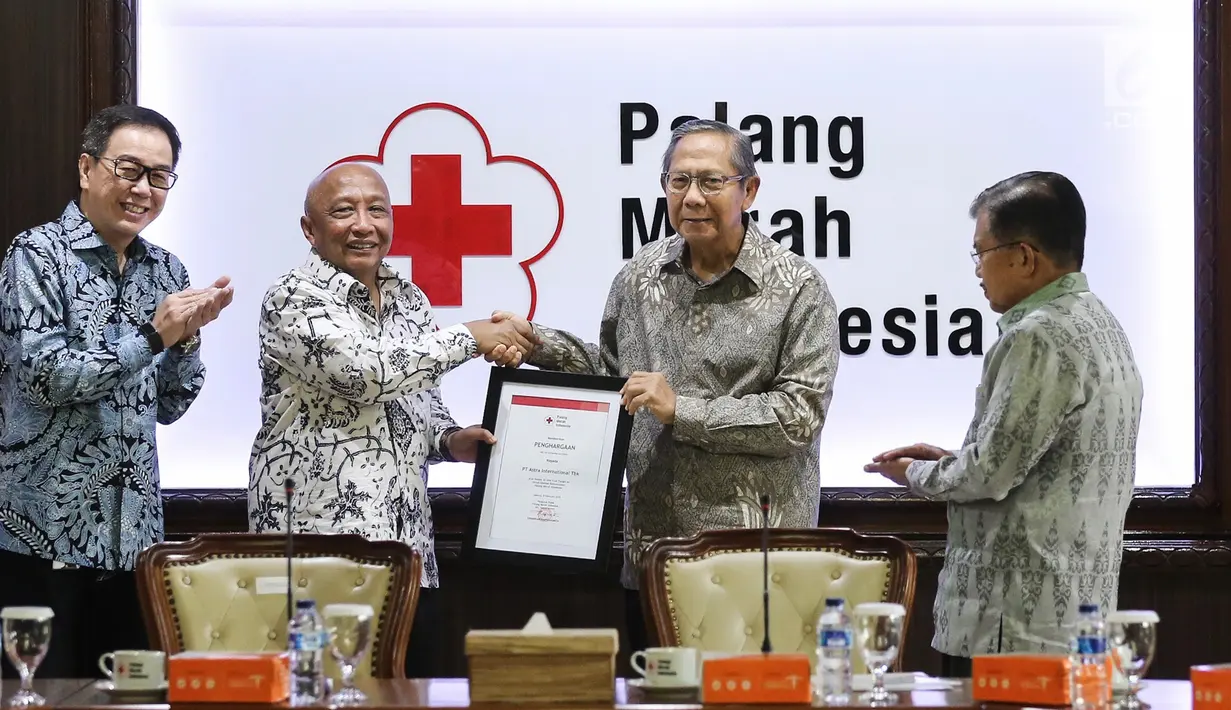 Plh Ketum PMI Ginandjar Kartasasmita memberikan penghargaan kepada Astra International yang diwakili Chief of Corcomm, Social Responsibility & Security Astra International Pongki Pamungkas di Kantor PMI, Jakarta, Jumat (8/2). (Liputan6.com/Fery Pradolo)