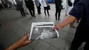 Warga membawa surat kabar berisi berita wafatnya Raja Thailand Bhumibol Adulyadej di Bangkok, Jumat (14/10). Hingga akhir hayatnya, Raja Bhumibol Adulyadej merupakan raja yang paling lama berkuasa di dunia. (Reuters/Edgar Su)