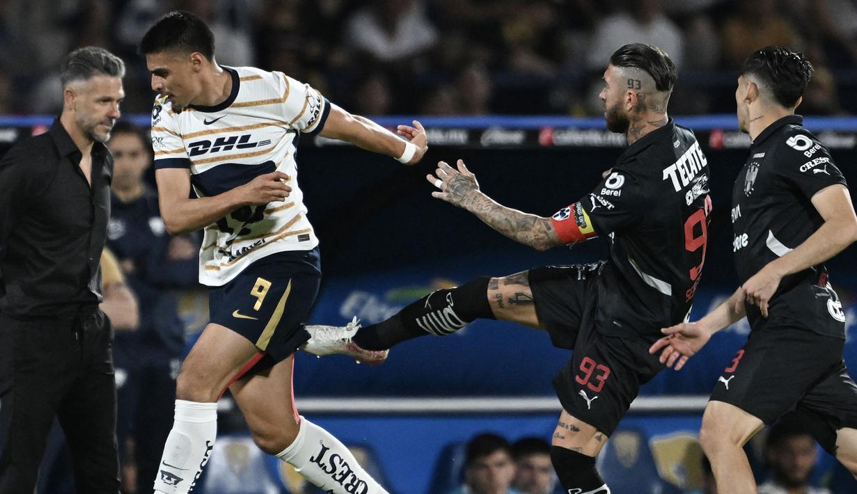 Pemain Monterrey, Sergio Ramos (kiri) (tengah kanan) melakukan gerakan menendang ke tubuh pemain Puma, Guillermo Martinez dalam laga lanjutan Liga Meksiko atau Liga MX Clausura di Olimpico Universitario Stadium, Meksiko pada Minggu (16/03/2025). (AFP/Yuri Cortez)
