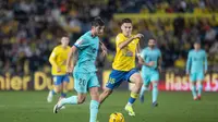 Gelandang Barcelona Sergi Roberto mencoba melewati bek Las Palmas Mika Marmol dalam pertandingan La Liga Spanyol di&nbsp; Estadio de Gran Canaria, Jumat, 5 Januari 2024. (DESIREE MARTIN / AFP)
