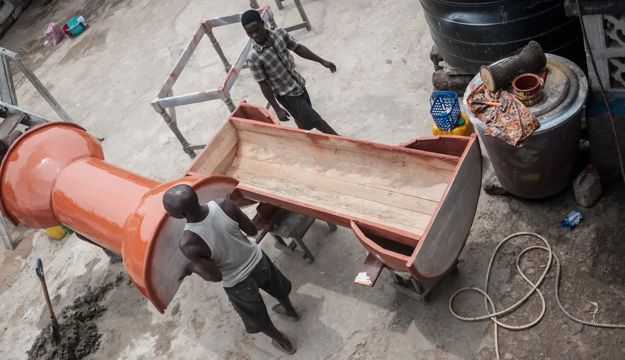 Pembuat peti mati di kota Accra sedang menyelesaikan pembuatan peti, Ghana (10/10). Di Ghana orang yang meninggal akan dimasukan ke dalam peti mati yang melambangkan segala hal kehidupannya. (AFP Photo/Stefan Heunis)