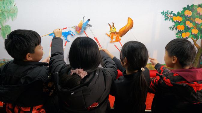 Para siswa belajar memainkan wayang kulit di Sekolah Dasar Xiyoucun di Kota Shahe, Provinsi Hebei, China utara, pada 24 November 2020. (Xinhua/Fan Shihui)