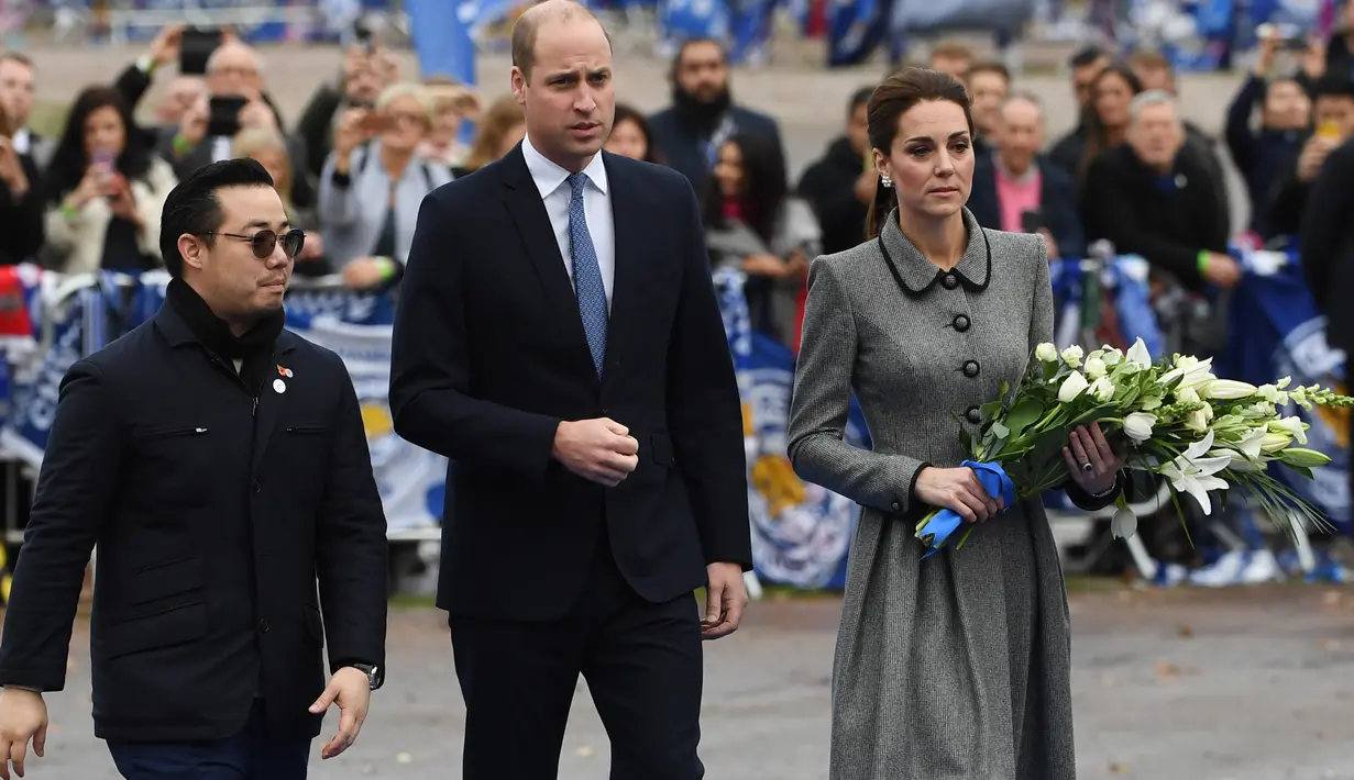 Putra Vichai, Aiyawatt Srivadhanapraba mendampingi Pangeran William dan Kate Middleton untuk memberikan penghormatan kepada korban tewas dalam kecelakaan helikopter di markas Leicester City, Stadion King Power, di Inggris, Rabu (28/11). (Paul ELLIS/AFP)