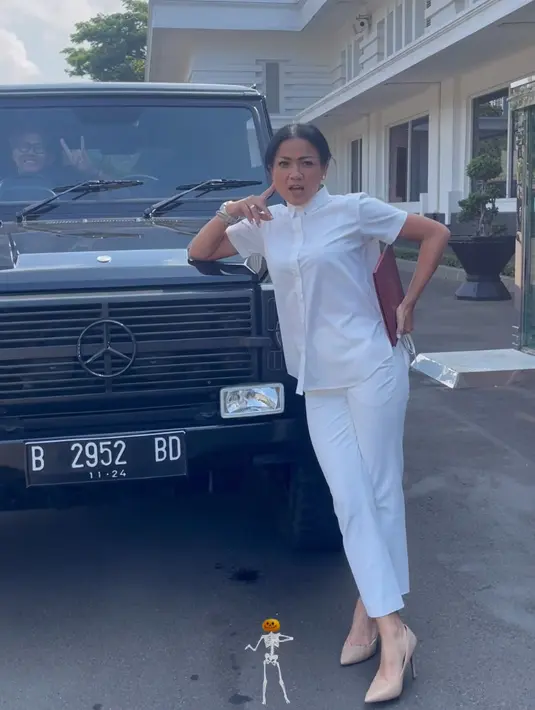 Nirina Zubir tampil serba putih, mengenakan kemeja lengan pendek dan celana bahannya. Dipadukan stiletto heels warna nude. [@iko.uwais]
