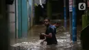 Warga beraktivitas di tengah banjir yang merendam kawasan Kebon Pala, Kampung Melayu, Jakarta Timur, Sabtu (16/7/2022). Meskipun ketinggian air sudah mencapai paha orang dewasa, warga setempat belum memutuskan untuk mengungsi. (merdeka.com/Imam Buhori)