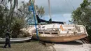 Seorang pria mengambil gambar sebuah kapal yang terhempas ke daratan akibat terhempas badai Irma di Coconut Grove, Florida, Senin (11/9). Badai Irma menghantam negara bagian Florida dengan kecepatan angin mencapai 200 km/jam. (SAUL LOEB/AFP)