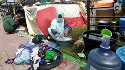 Pengungsi korban gempa dan tsunami Palu mencuci pakaian di tenda pengungsian lapangan Walikota Palu, Sulawesi Tengah, Senin (8/10). Pemerintah tengah menentukan lokasi yang tepat untuk membangun hunian sementara bagi korban. (Liputan6.com/Fery Pradolo)