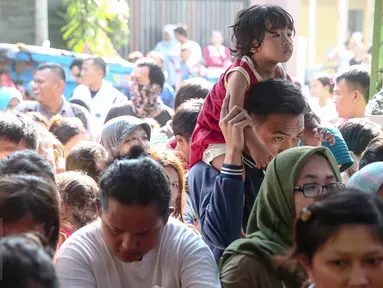 Sejumlah anak kecil iku mengantri saat kegiatan pasar murah di Jakarta, (12/6). Pasar murah yang diselenggarakan oleh Hati Suci tersebut bertujuan sebagai wadah untuk saling berbagi kepada sesama. (Liputan6.com/Faizal Fanani)