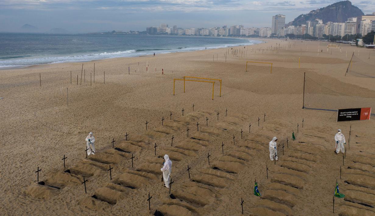 Aktivis LSM Rio de Paz menggali kuburan sebagai bentuk protes di pantai Copacabana, Rio de Janeiro, Kamis (11/6/2020). Kuburan-kuburan dengan simbol salib hitam yang dihiasi bendera Brasil kecil itu untuk mengenang puluhan ribu pasien corona yang meninggal di negara tersebut. (AP Photo/Leo Correa)