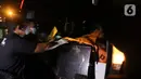 Tim DVI Polri membawa kantong jenazah yang diduga berisi bagian tubuh penumpang pesawat Sriwijaya Air SJ 182 di Dermaga JICT 2, Jakarta, Minggu (10/1/2021) dini hari. Sriwijaya Air SJ 182 hilang kontak empat menit usai lepas landas dari Bandara Soetta. (Liputan6.com/Helmi Fithriansyah)