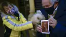 Fernando Hipolito (82 tahun) memegang kelinci peliharaannya dan kartu religius untuk diberkati saat pesta Santo Antonius di Pamplona, Spanyol, 17 Januari 2022. Pesta ini dirayakan setiap tahun dan orang-orang membawa hewan peliharaan mereka ke gereja untuk diberkati. (AP Photo/Alvaro Barrientos)