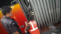 Petugas sedang memperbaiki sambungan bus gandeng transjakarta yang terbelah di kawasan Jatinegara, Jakarta, Kamis (7/8/14). (Liputan6.com/Faizal Fanani)