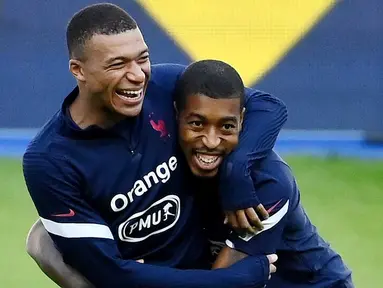 Penyerang Prancis, Kylian Mbappe, bercanda dengan Presnel Kimpembe, saat sesi latihan jelang laga UEFA Nations League di Paris, Senin (7/9/2020). Pemain muda PSG itu akan absen melawan Kroasia karena dinyatakan positif terjangkit COVID-19. (AFP/Franck Fife)