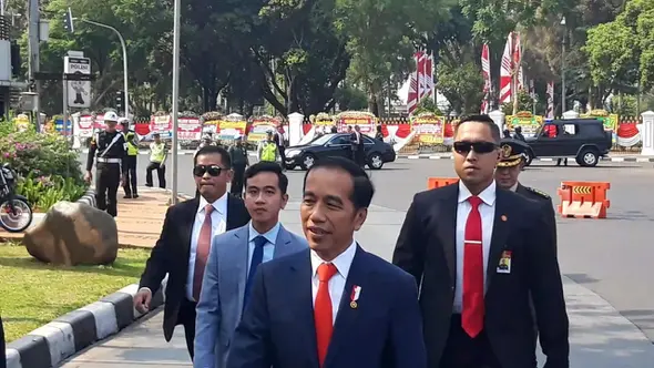 Saat kendaraan melintas di depan Taman Pandang, Monas, Jokowi tiba-tiba menghentikan laju kendaraannya. Bersama Gibran sang putra sulungnya, Jokowi tiba-tiba keluar dari mobil.