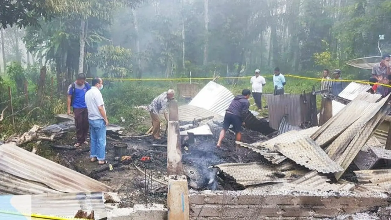 Polisi dan warga membersihkan puing-puing kebakaran di Kabupaten Kuantan Singingi.