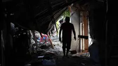 Warga berjalan melewati puing-puing rumah yang rusak akibat gempa di General Santos, Filipina, Selasa 9 Juni 2026. (AP Photo/Basilio Sepe)