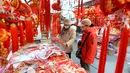 Orang-orang membeli pernak-pernik dekorasi menjelang Hari Tahun Baru di sebuah pasar di Qingdao, di provinsi Shandong timur China pada 25 Desember 2022. Warga China mulai berburu pernak-pernik Tahun Baru seperti lampion, kartu tahun baru, baju, dan hiasan rumah. (AFP/China Out)