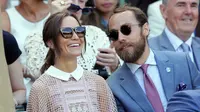 Pippa Middleton bersama adiknya, James Middleton, menyaksikan hari ketiga kejuaraan tenis Grand Slam Wimbledon 2017 di London, Rabu (5/7). Adik Kate Middleton itu menebar pesonanya dalam balutan dress pink berbahan menerawang.  (AP Photo/Tim Ireland)